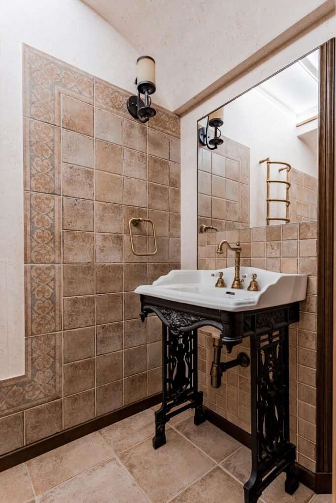 Stylish vintage-style bathroom with ornate sink, tiled walls, and classic fixtures.